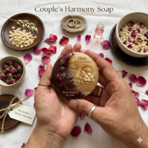 A crescent moon-shaped soap bar titled The Petal & Grain Moon. One half is a soft, natural rose-pink and the other a warm, textured cream color with oat flecks. It is styled on a dark slate tray with fresh pink rose petals and a scattering of raw oats under soft, dramatic lighting.